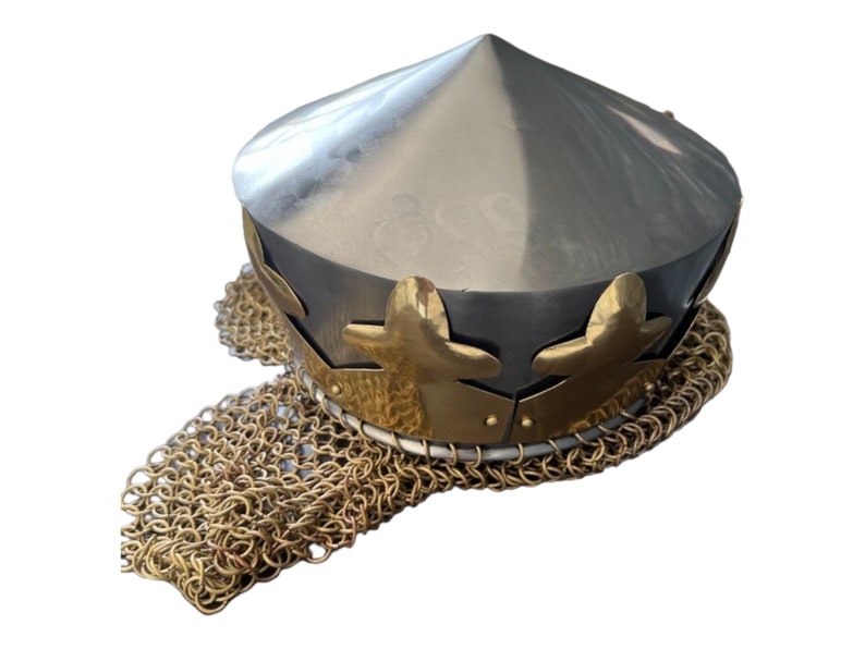 May include: A silver metal helmet with a conical top and a gold chainmail coif. The helmet has a gold band with decorative leaf-shaped accents.