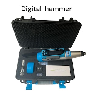 May include: A digital hammer concrete test tool in a black case. The tool is blue and silver with a digital display. The case contains additional blue and silver components and a white card with text. The text "Digital hammer" is above the case.