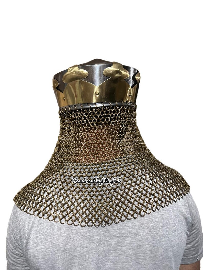 May include: A gold and silver helmet with a chainmail neck guard. The helmet has a pointed top and a decorative band around the base. The chainmail is made of small, interlocking rings.