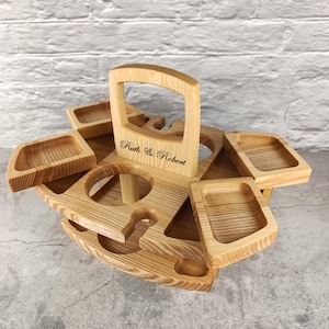 Könnte beinhalten: Ein Holztablett mit einem Griff und sechs einzelnen Fächern. Das Tablett ist mit den Namen "Ruth & Robert" graviert.