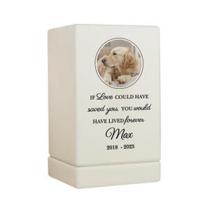 May include: White ceramic pet urn with a photo of a golden retriever dog. The urn has the text "If love could have saved you, you would have lived forever" and the name "Max" with the dates "2018 - 2025".