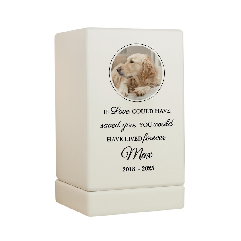 May include: White ceramic pet urn with a photo of a golden retriever dog. The urn has the text "If love could have saved you, you would have lived forever" and the name "Max" with the dates "2018 - 2025".