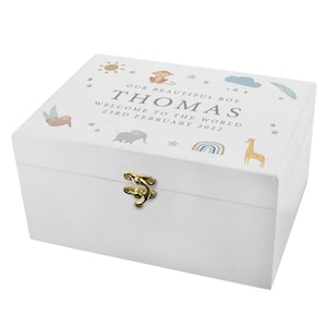 May include: White wooden keepsake box with a gold latch. The lid features a colorful illustration of a sun, clouds, stars, a monkey, a sloth, an elephant, a rainbow, and a giraffe. The text on the lid reads "Our beautiful boy Thomas Welcome to the world 23rd February 2022".