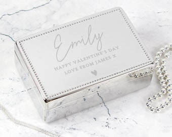 May include: Silver jewelry box with a personalized inscription that reads "Emily Happy Valentine's Day Love from James x" with a small heart symbol.
