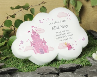 May include: White ceramic cloud-shaped memorial with a pink castle and a fairy illustration. The text reads "Our Little Angel Ellie May We will hold you in our hearts until we hold you in heaven. 7th August 2024".
