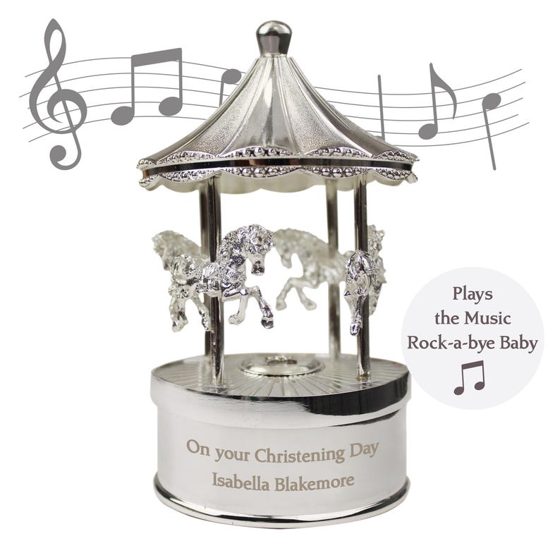 Peut inclure: Carrousel musical en argent avec quatre chevaux, joue la chanson "Dodo l'enfant do". La base est grav&eacute;e avec "On your Christening Day Isabella Blakemore".