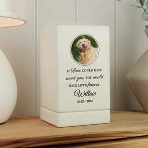 May include: White ceramic pet memorial with a photo of a golden retriever dog. The text reads "If love could have saved you, you would have lived forever. Willow 2013-2025"