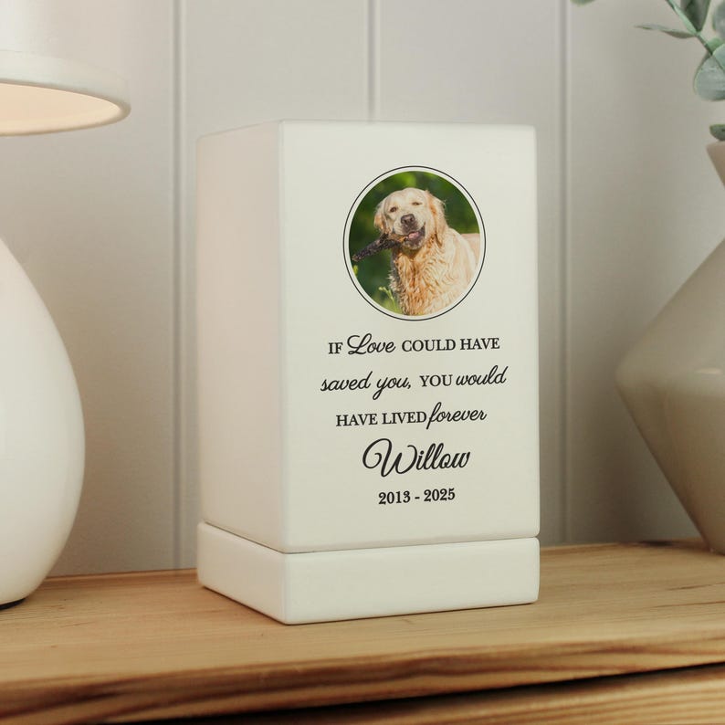 May include: White ceramic pet memorial with a photo of a golden retriever dog. The text reads "If love could have saved you, you would have lived forever. Willow 2013-2025"
