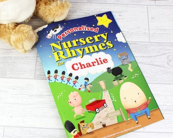 May include: A personalized children's book with a blue cover and the title "Personalized Nursery Rhymes for Charlie". The book features colorful illustrations of animals, a star, and a well.