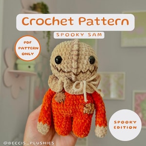 May include: Crochet pattern for a spooky Sam doll. The doll is made of orange and beige yarn and has a stitched-on smile. The pattern is available as a PDF download only.