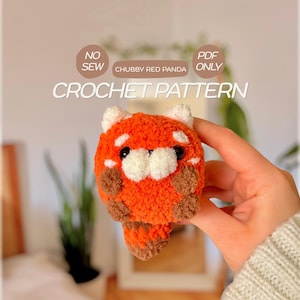 Könnte beinhalten: Ein kleines, rundes, gehäkeltes rotes Panda-Stofftier aus orangefarbenem, weißem und braunem Garn. Der Text auf dem Bild lautet: NO SEW, CHUBBY RED PANDA, PDF ONLY, CROCHET PATTERN. Das Stofftier hat schwarze Augen, weiße Gesichtsflecken und einen gestreiften Schwanz.