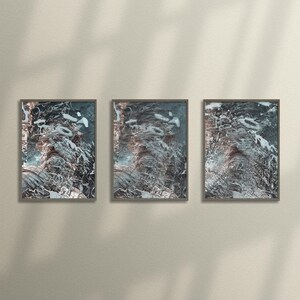 May include: Three framed abstract art prints featuring a swirling, textured design in shades of blue, white, and grey.