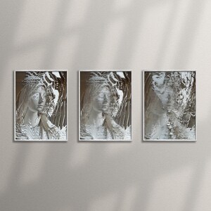 May include: Three framed abstract art prints with a white background and a grey and white design. The design is reminiscent of a person's face.