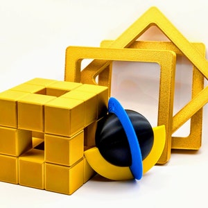 Puede incluir: Un cubo geométrico amarillo con un centro hueco, rodeado por tres marcos cuadrados amarillos. Los marcos están apilados uno encima del otro, con el marco más grande en la parte inferior. Una esfera negra y azul con un anillo amarillo y azul está delante del cubo.