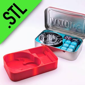 May include: A silver tin with a teal interior holds dice and a game piece. A red tray sits in front. The tin has the word "VINTAGE" on the inside. The text ".STL" is in the upper left corner.