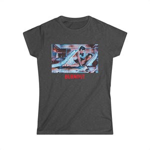 May include: Dark grey t-shirt featuring a graphic print of a couple in a passionate embrace, with the word "BURNOUT" in red block letters. The artwork depicts a woman in a white dress and a man on a bed. The shirt is made of a soft material.