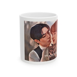 May include: White ceramic mug featuring a romantic illustration of two people embracing. The artwork depicts two individuals with dark hair and a soft, warm color palette. The text "THE NEXT P" is visible on the mug.