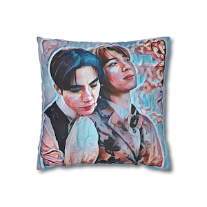 May include: Square decorative pillow featuring a digital art print of two people embracing. The artwork has a soft, painterly style with a color palette of blues, pinks, and browns. The pillow has a light blue border.