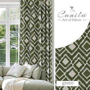 May include: Green patterned curtains with a white background. The pattern is a geometric design of diamonds and squares. The curtains are shown hanging in a window with a couch in front of them. The text "Canila - Art of Fabric" is in the upper right corner of the image. The word "green" is in the lower right corner of the image.