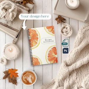 Può includere: Un quaderno a spirale bianco con un design ad acquerello di fette d'arancia. Il quaderno dice "Recipes Notebook" sulla copertina.