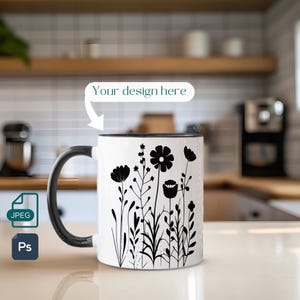 May include: A white ceramic mug with a black rim and handle. The mug features a black silhouette design of stylised flowers and leaves. The text "Your design here" is visible above the mug.
