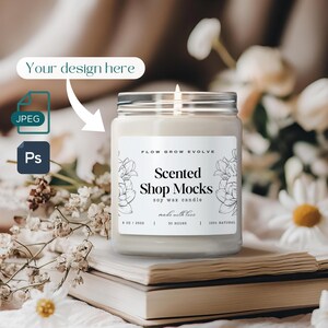 Peut inclure: Une bougie blanche avec une étiquette noire et blanche qui dit "FLOW GROW EVOLVE Scented Shop Mocks soy wax candle made with love 8 OZ / 2500 30 HOURS 100% NATURAL". La bougie est posée sur une pile de livres.