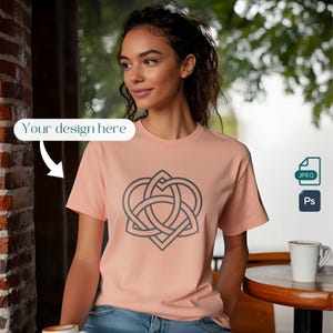 May include: A peach-colored t-shirt with a black Celtic knot design in the shape of a heart. The design is centered on the shirt.