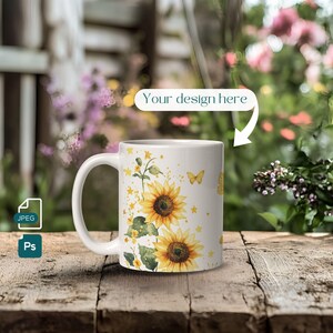 May include: White ceramic mug with a design of sunflowers, butterflies, and stars. The mug is on a wooden surface.