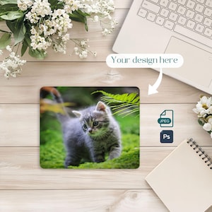 May include: Square mousepad featuring a gray tabby kitten standing on green moss. The mousepad has the text "Your design here" and icons for JPEG and Ps.