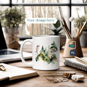 May include: White ceramic mug featuring a watercolour design of a woodland scene. The design depicts green and brown trees against a white background.