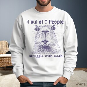 May include: White sweatshirt with a purple graphic of a capybara and the text "4 out of 3 People struggle with math".