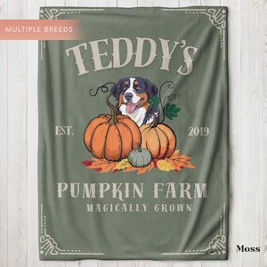 May include: A moss green blanket featuring a Bernese Mountain Dog illustration with pumpkins and fall leaves. The blanket reads "TEDDY'S PUMPKIN FARM" with the text "EST. 2019" and "MAGICALY GROWN". The blanket is rectangular.