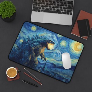 May include: A rectangular mousepad featuring a stylized image of Godzilla in a starry night setting. The design incorporates elements of Van Gogh's "Starry Night" with a blue and yellow color palette. A white computer mouse rests on the pad.