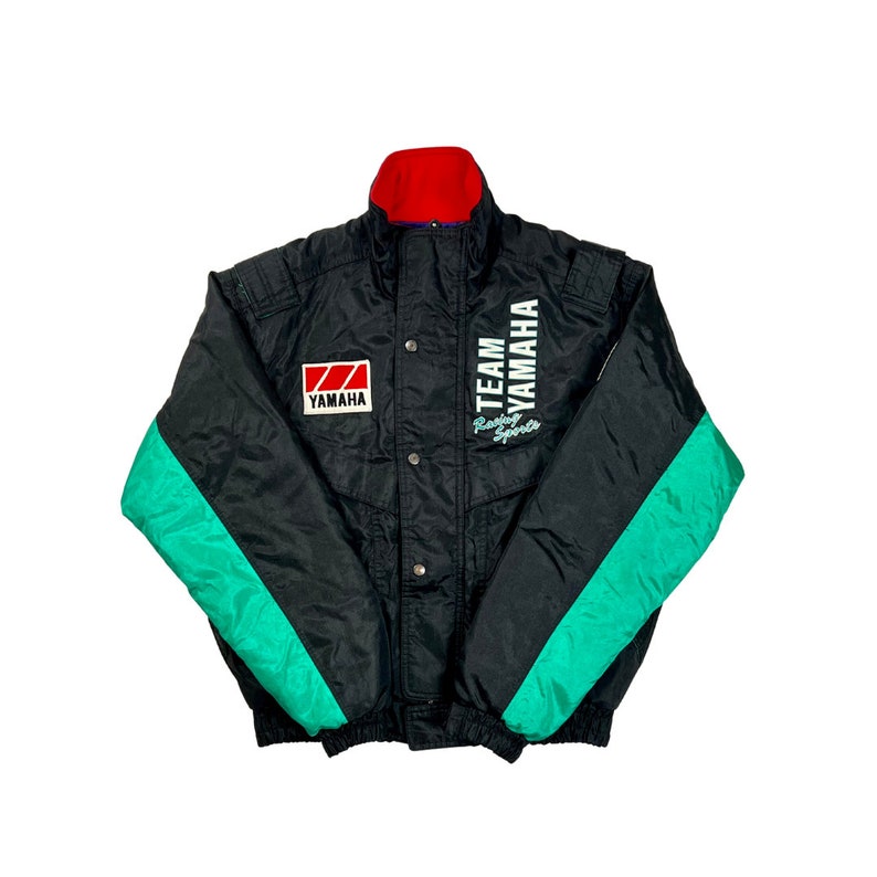 K&ouml;nnte beinhalten: Schwarze und gr&uuml;ne Skijacke mit dem Text "Team Yamaha Racing Sports" und einem Yamaha-Logo auf der Vorderseite.
