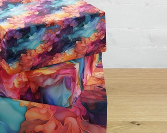 May include: Three stacked gift boxes featuring a colourful abstract design. The boxes are wrapped in a vibrant pattern of swirling colours, including shades of pink, blue, orange, and purple.