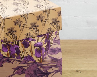 May include: Two stacked gift boxes with floral patterns. The top box is beige with a delicate floral design in shades of brown. The bottom box is beige with a larger floral design featuring purple irises.