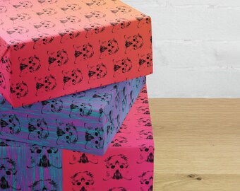 Könnte beinhalten: Drei Geschenkboxen, die übereinander gestapelt sind. Die oberste Box ist rosa mit einem schwarz-weißen Muster aus Tiergesichtern. Die mittlere Box ist blau mit einem schwarz-weißen Muster aus Tiergesichtern. Die unterste Box ist rosa mit einem schwarz-weißen Muster aus Tiergesichtern.