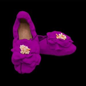 May include: A pair of purple satin slippers with a flower design and pearl embellishments.