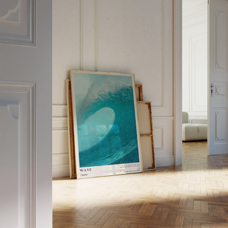 May include: A framed poster with a photograph of a large, turquoise wave crashing. The poster has a white background with the word "WAVE" in black text and the word "/weiv/" in smaller black text below it.