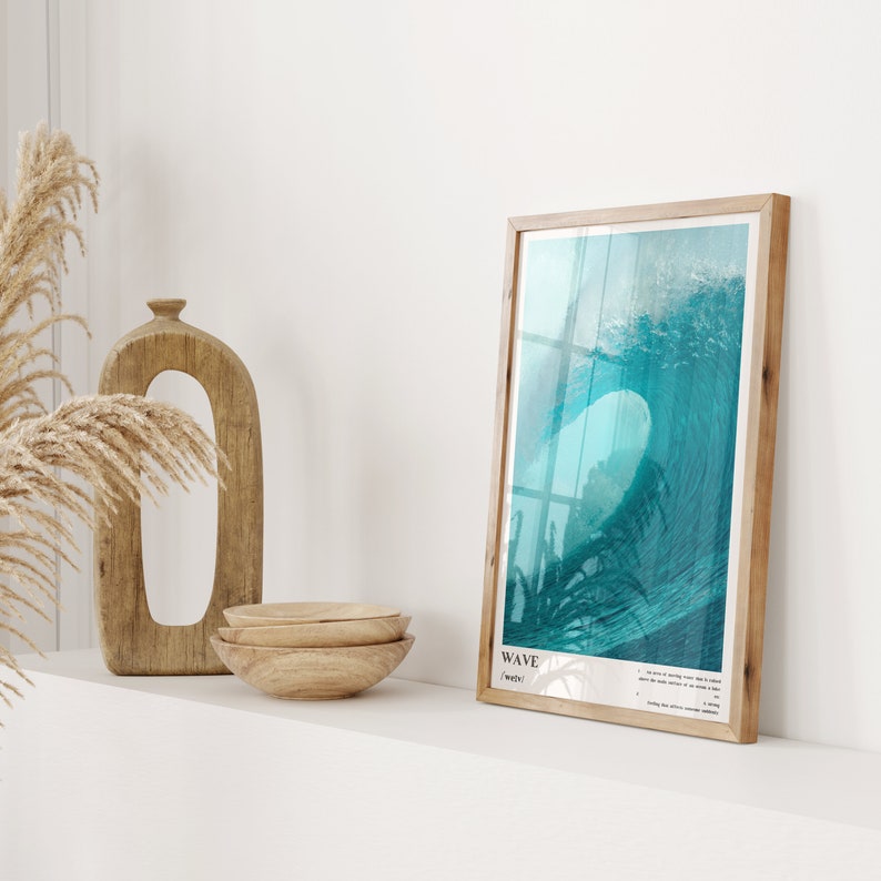 May include: A framed print of a turquoise wave crashing against a white background. The print is titled "WAVE" and includes a description of the wave.