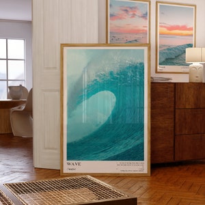 May include: A framed poster with a blue and green watercolor painting of a large wave crashing. The poster has the word "WAVE" and the phonetic spelling "/weɪv/" printed below the image.