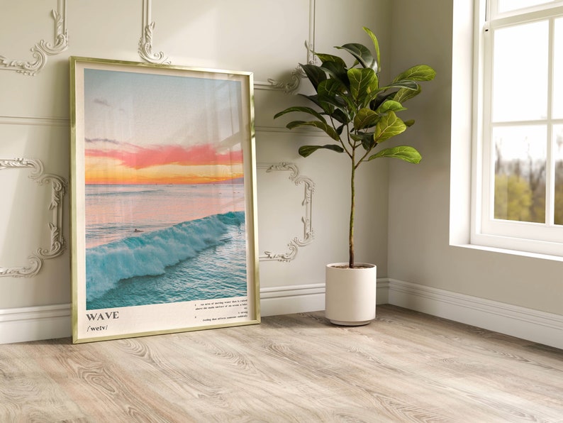 May include: A framed print with a photograph of a large wave crashing in the ocean at sunset. The print has the word "WAVE" and the definition "/weɪv/" printed below the image.