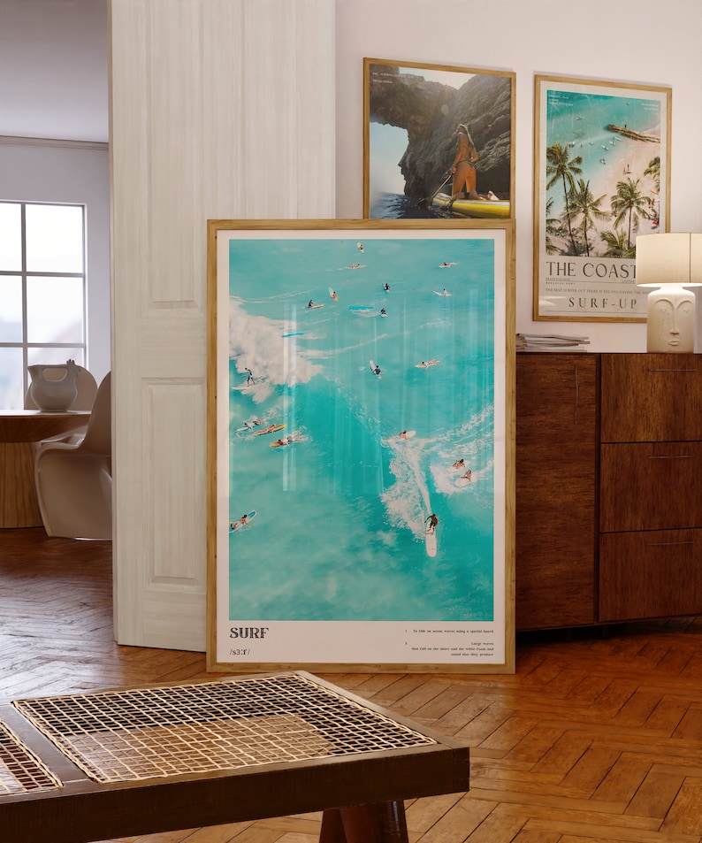 May include: A framed poster with a turquoise blue background featuring a group of surfers riding waves. The poster has the word "SURF" in white text at the bottom and the text "1327" in smaller white text below the word "SURF".