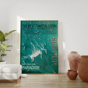 May include: A framed poster with a teal background featuring surfers in the ocean. The text on the poster reads "The West Coastal Living", "The best surfer out there is the one having the most fun", "Surfing is attitude dancing", "Surf Up!" and "Find your own paradise".