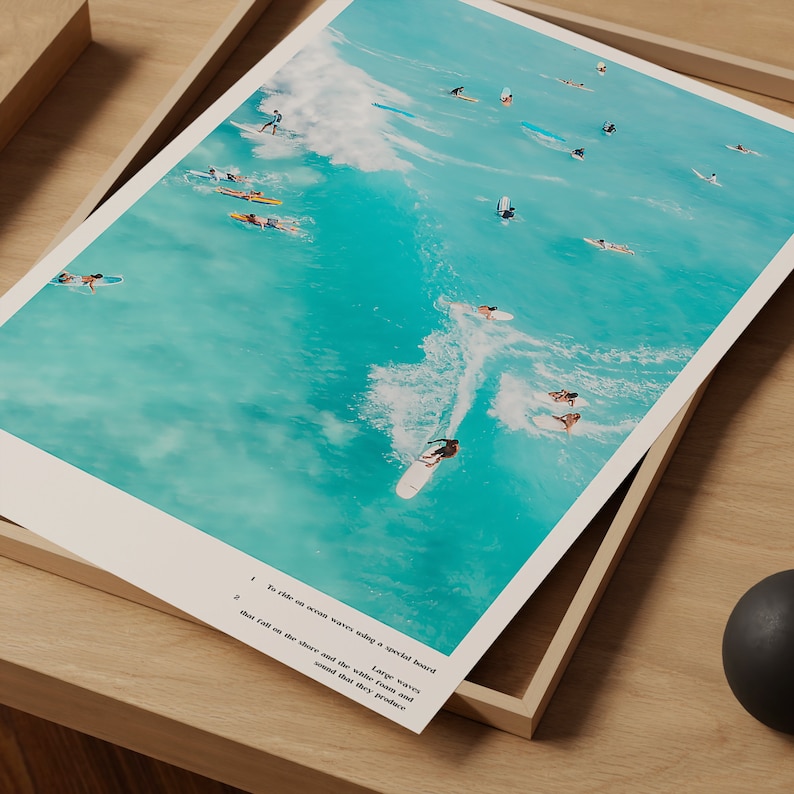 May include: An aerial view of surfers riding waves on a bright turquoise ocean. The surfers are riding on longboards and shortboards, and the waves are breaking in the distance.