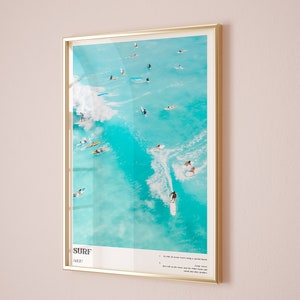 May include: A framed poster with a photograph of surfers riding waves in turquoise water. The poster has the word "SURF" in bold, black letters and a list of instructions for surfing.