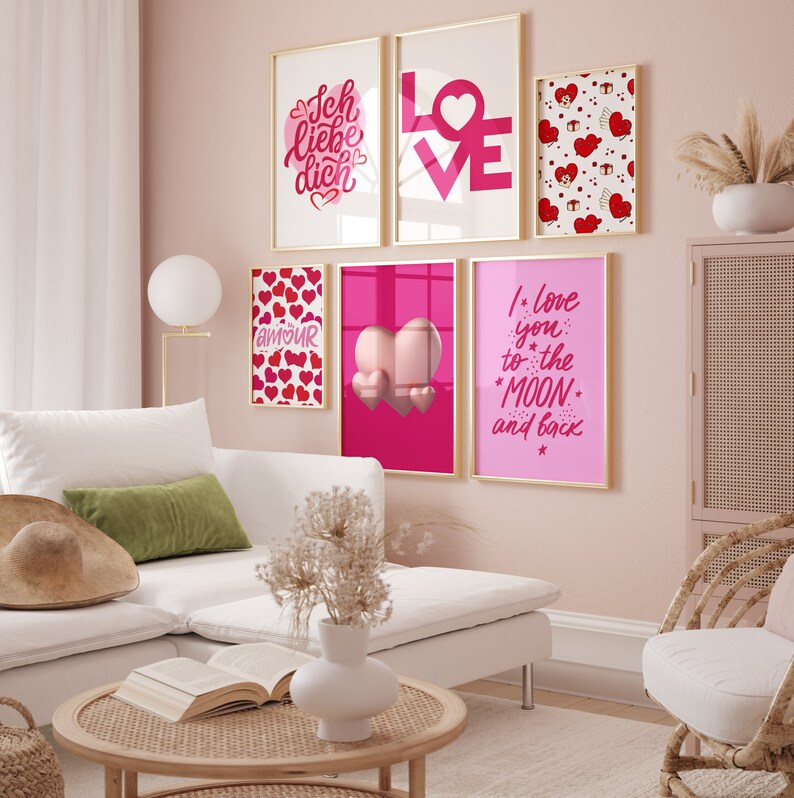 May include: A living room with a white sectional sofa, a pink wall, and a collection of framed prints with love-themed designs. The prints feature hearts, the word "love" in different languages, and romantic phrases.