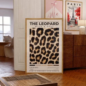 May include: A framed poster with a leopard print design. The poster has the text "THE LEOPARD WILD & SEXY" at the top and "LEOPARD /ˈlepərd/" at the bottom.