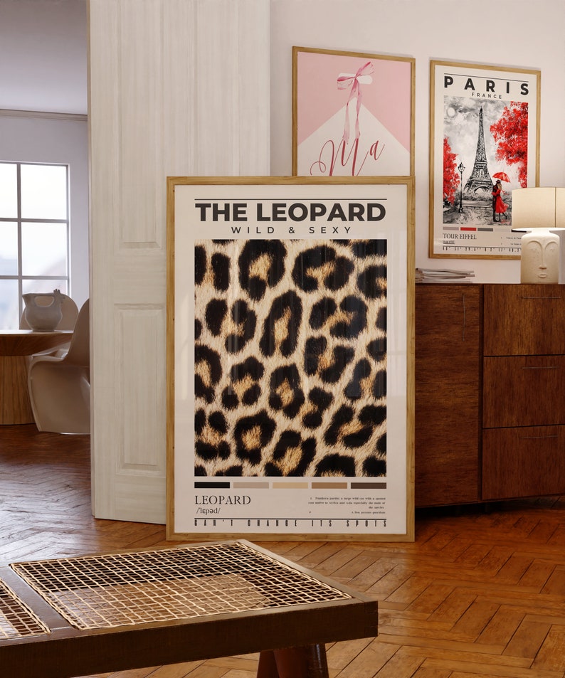 May include: A framed poster with a leopard print design. The poster has the text "THE LEOPARD WILD & SEXY" at the top and "LEOPARD /ˈlepərd/" at the bottom.