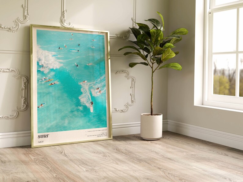 May include: A framed poster with a turquoise blue background featuring a group of surfers riding waves. The poster has the word "SURF" in white text at the bottom and the text "NEXT" in smaller white text below the word "SURF".